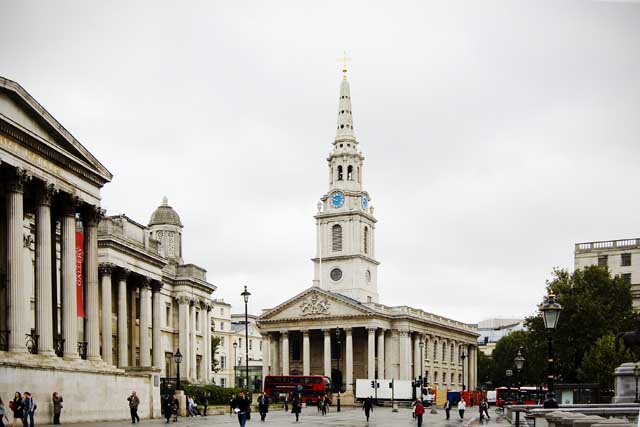 The National Portrait Gallery is off to the left of Trafalgar Square. St Martin in the Field's church is seen to the left.