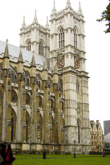 The tall square towers of Westminster Abbey, in grey stone, are seen from Parliament Square.