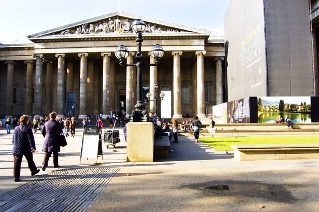 The picture shows the imposing front entrance of the British Museum busy with the many visitors coming and going.