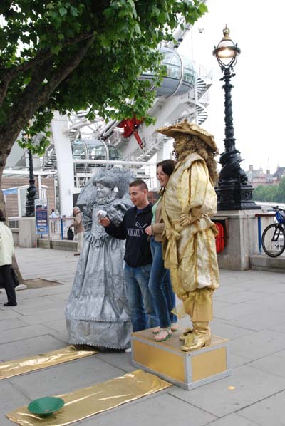 Entertainment on the South Bank Centre with a costumed couple of living statues posing for photographs with two visitors.