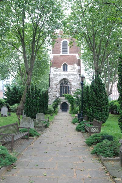 The stone and brick tower of St Mary's Church can be seen at the end of the path, framed by trees.